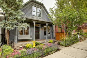 View of front facade with covered porch and a fenced front yard