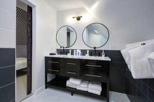Ensuite bathroom with double vanity and tile walls