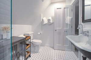 Full bath featuring lofted ceiling