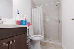 Bathroom featuring vanity and a marble finish shower