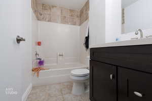Bathroom featuring  shower combination, vanity, and light tile patterned flooring