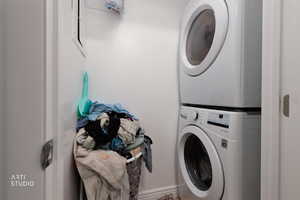 Laundry room featuring stacked washing machine and dryer