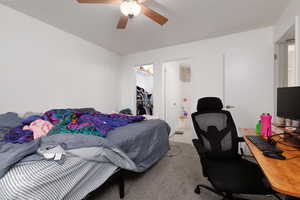 Bedroom featuring carpet floors, a walk in closet, ceiling fan, and a desk