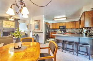 Dining area with a ceiling fan, a fireplace, and a textured ceiling