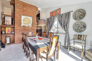 Dining area featuring carpet and brick wall