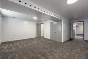 Unfurnished room featuring dark carpet