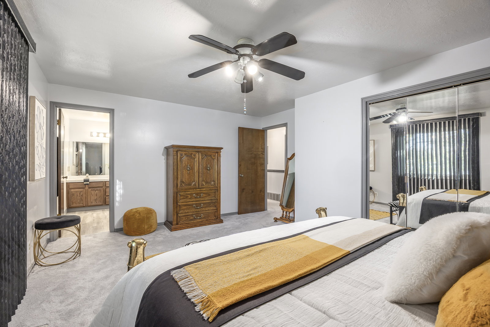 Bedroom featuring carpet, ceiling fan, a closet, and connected bathroom