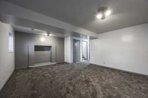 Unfurnished room with dark colored carpet and stairway