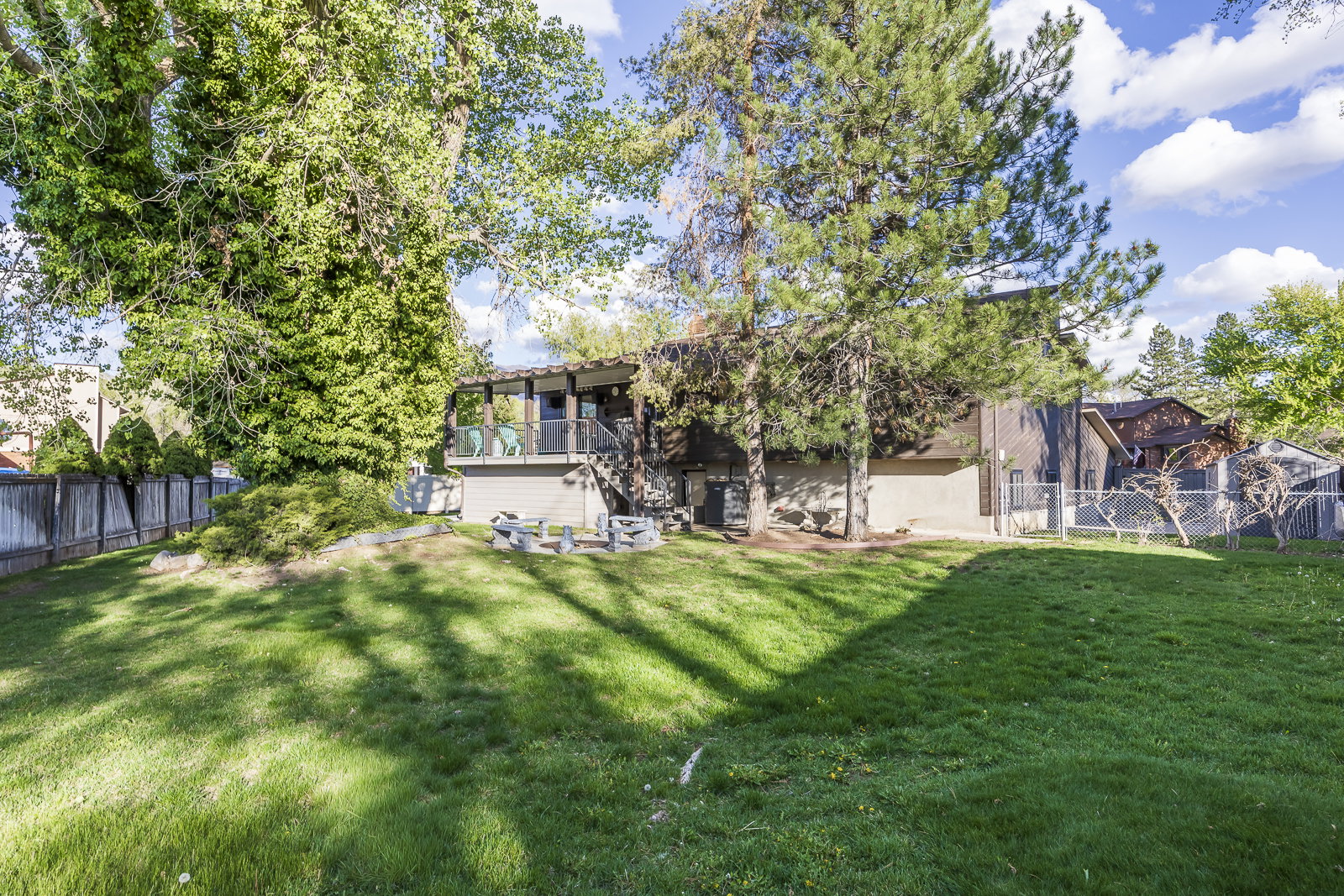 Rear view of house featuring a fenced backyard and a gate
