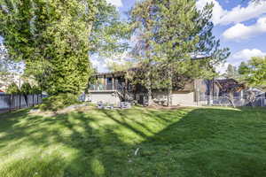 Rear view of house featuring a fenced backyard and a gate