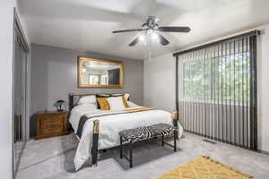 Bedroom featuring light colored carpet, ceiling fan, and a textured ceiling