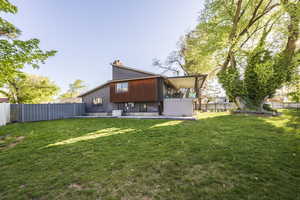 Back of property featuring a fenced backyard and a chimney