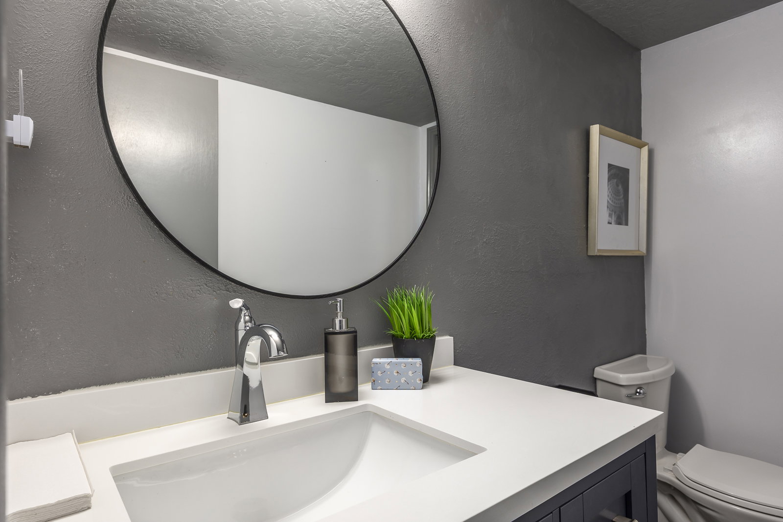 Half bathroom featuring vanity and a textured wall