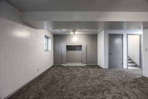 Unfurnished room with dark carpet and stairs