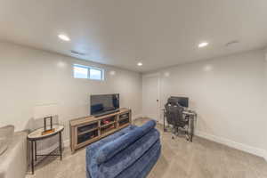Living room featuring recessed lighting, light carpet, and an office area