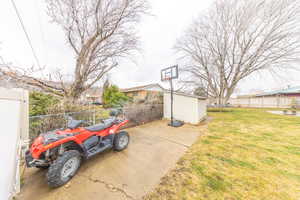Fenced backyard with a trampoline and a storage shed
