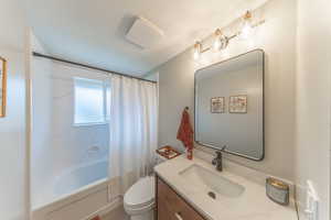 Full bathroom with shower / bath combo with shower curtain and vanity