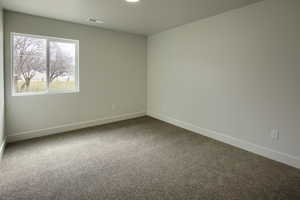 Unfurnished room featuring baseboards and carpet flooring