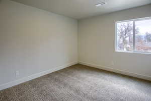 Carpeted empty room featuring baseboards