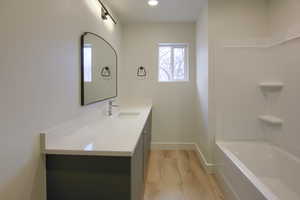 Full bathroom with vanity, light wood-type flooring, and  shower combination