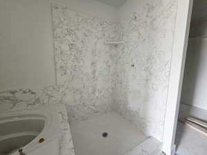 Bathroom with a stall shower and a sink