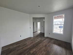 Empty room featuring dark wood-style flooring