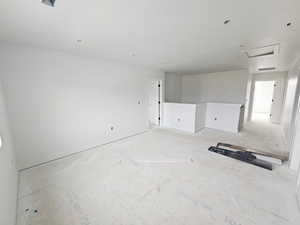 Unfurnished living room featuring attic access