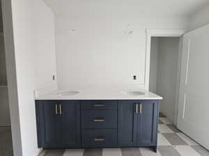 Full bathroom with light floors and double vanity