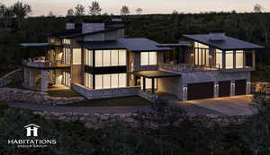 View of front facade with a chimney, an attached garage, stone siding, driveway, and a balcony
