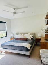 Carpeted bedroom with a ceiling fan
