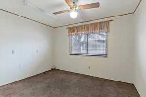 Unfurnished room with a ceiling fan and wooden walls
