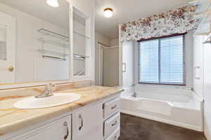 Bathroom with a bath, vanity, and a shower stall