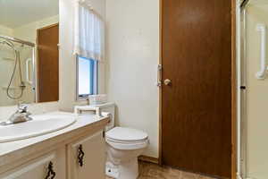 Bathroom featuring vanity, a shower, and stone finish flooring