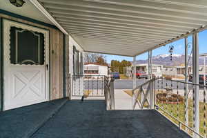 Covered porch with a mountain view, a residential view, and grilling area