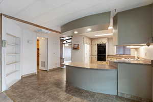 Kitchen featuring recessed lighting, built in shelves, white fridge with ice dispenser, and a peninsula