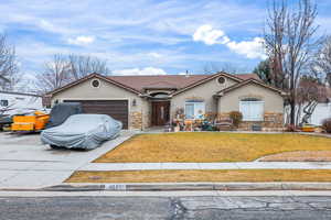 Mediterranean / spanish-style house featuring stucco siding, stone siding, driveway, and an attached garage