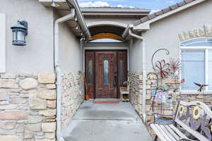 Entrance to property featuring stone siding and stucco siding