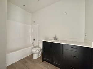 Full bath featuring vanity, shower / bath combination, and wood finished floors