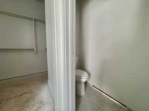 Bathroom featuring toilet and a walk in closet