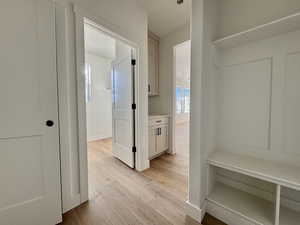 Mudroom with light wood-style floors and baseboards
