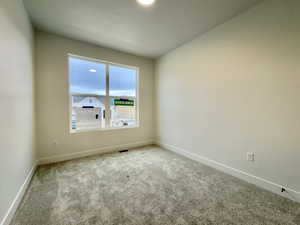 Carpeted empty room featuring baseboards