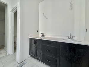 Full bathroom featuring double vanity and toilet