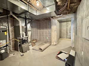 Unfinished basement with strapped water heater and heating unit