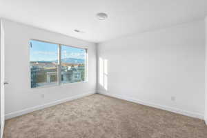 Spare room featuring carpet and a mountain view