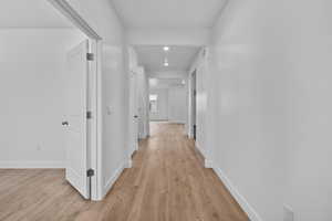 Hallway featuring light wood-style flooring and recessed lighting