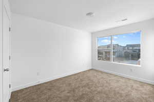 Carpeted spare room with baseboards