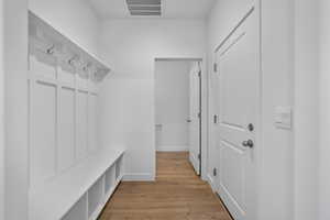 Mudroom featuring light wood-type flooring and baseboards