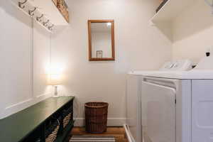 Laundry area featuring washing machine and dryer and dark wood-type flooring