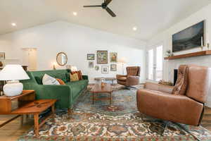 Living area featuring wood finished floors, a ceiling fan, a fireplace, and recessed lighting