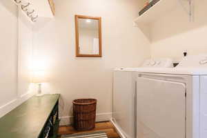Laundry room featuring wood finished floors and independent washer and dryer